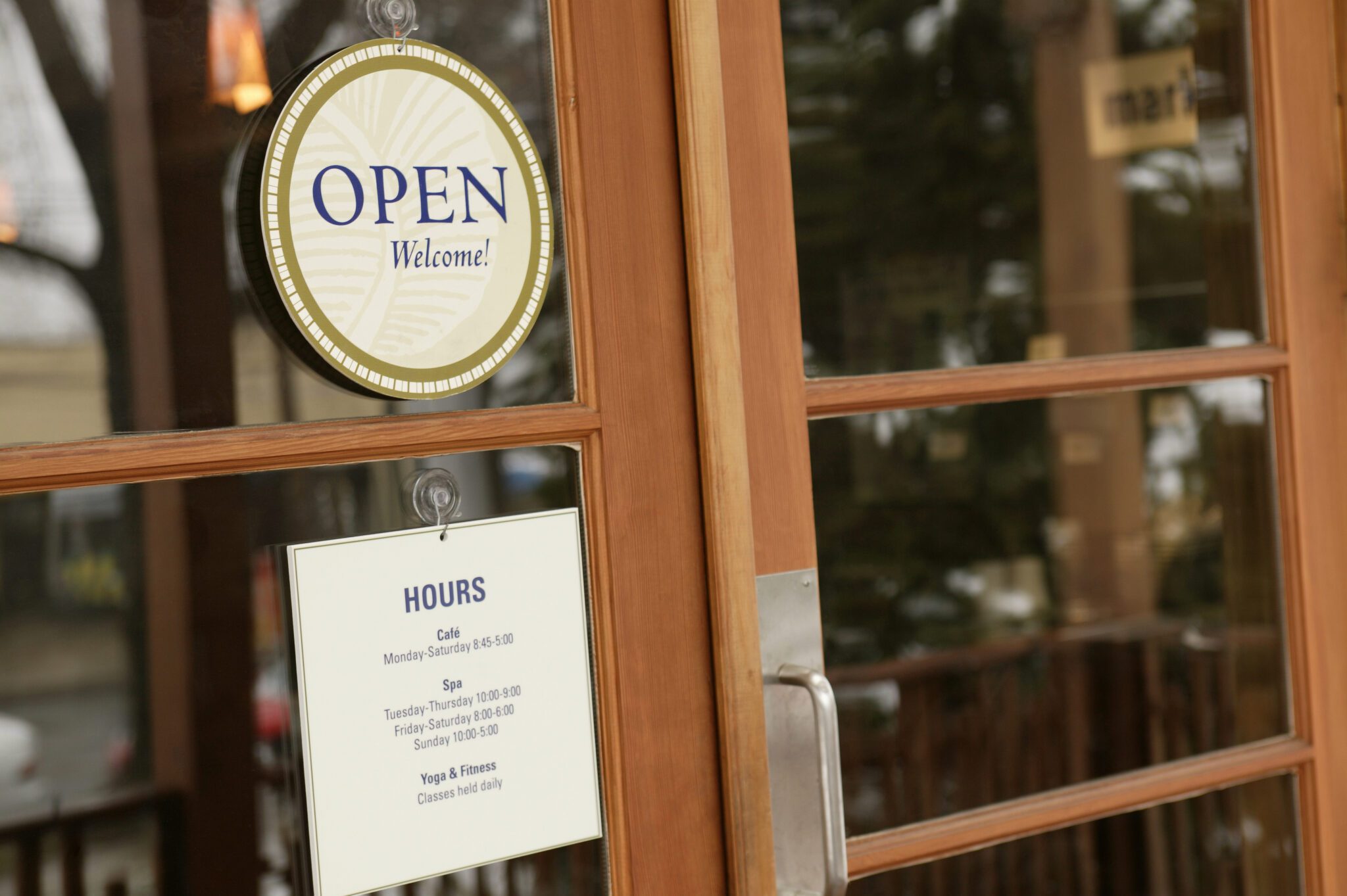 Front doors to small business with Open Welcome! sign