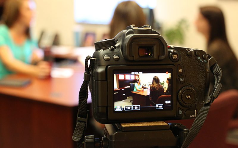 Camera videotaping women at a desk