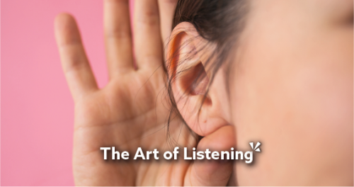 women with her hand up to her ear listening to someone