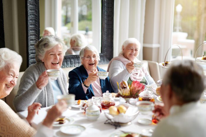 a group of seniors having tea in their retirement home