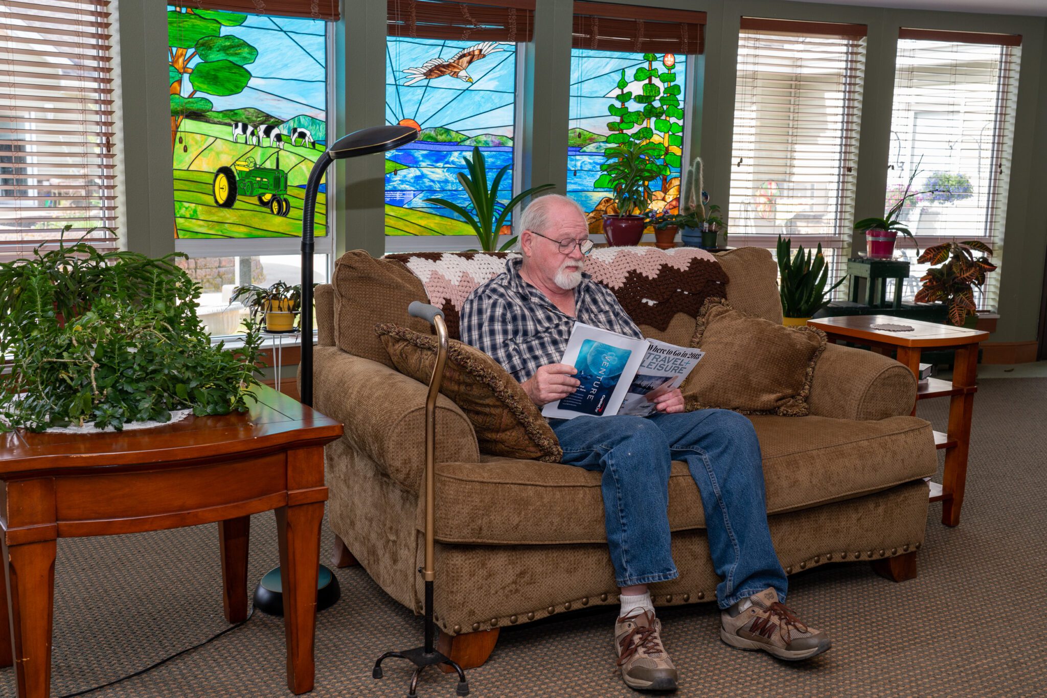 Senior man reading a magazine in a lounge area at Eldercare of Bemidji