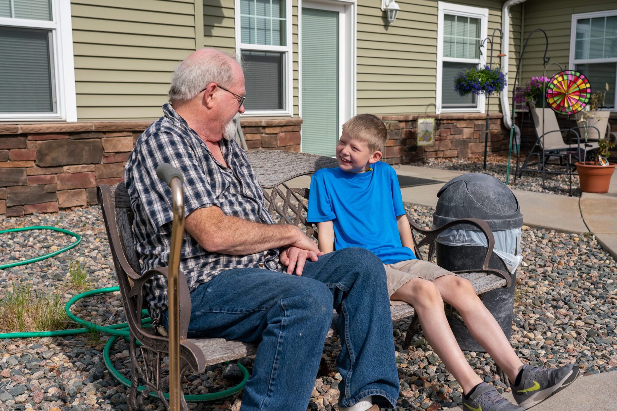 senior man sitting on a bench with a boy talking at Eldercare of Bemidji