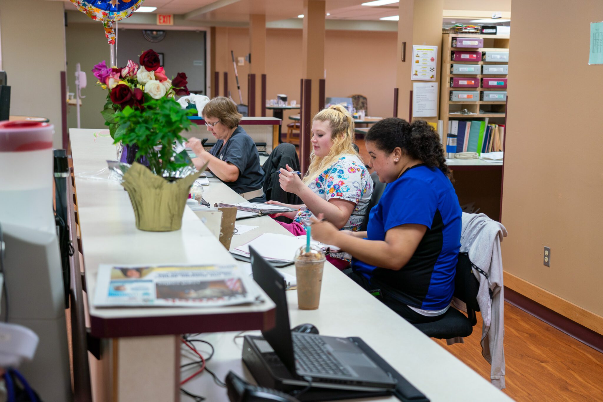 Eldercare of Bemidji receptionist's desk with three workers.