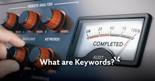 Text "What Are Keywords?" with background image of a hand turning black and orange dial to 100% and larger 0 to 100% speedometer turned up to 100% completed to the right of dials