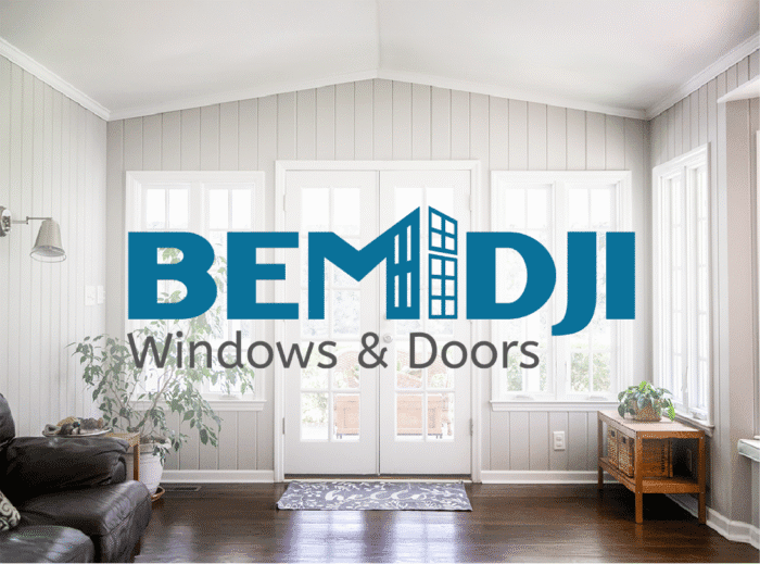 Bemidji Windows and Doors logo displayed over a bright, modern sunroom interior with white-framed windows and double doors.