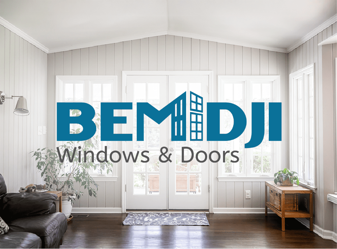 Bemidji Windows and Doors logo displayed over a bright, modern sunroom interior with white-framed windows and double doors.